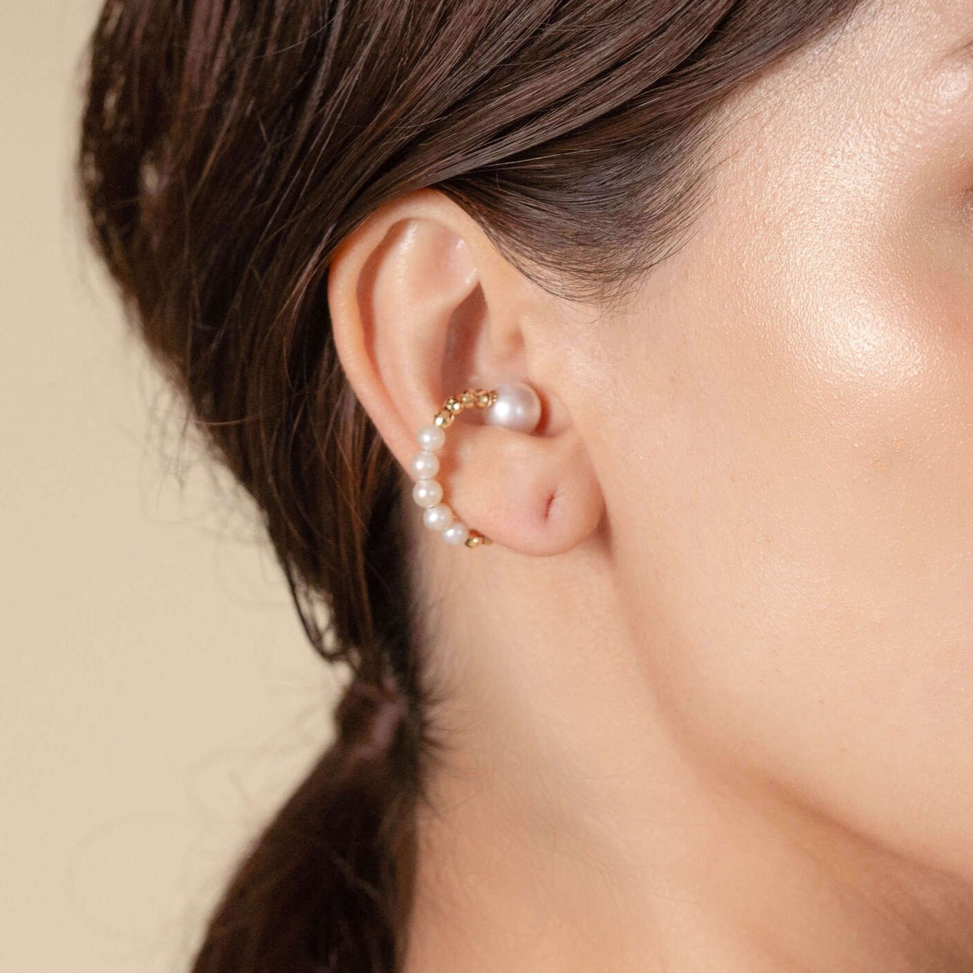 Enhance your style with a stunning Twin Pearl Earcuff worn by a fashionable woman. Elevate your look effortlessly!