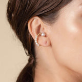 Enhance your style with a stunning Twin Pearl Earcuff worn by a fashionable woman. Elevate your look effortlessly!