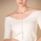 Enhance your elegance with a stunning woman in a white top and a Mantel Pearl Necklace Long.