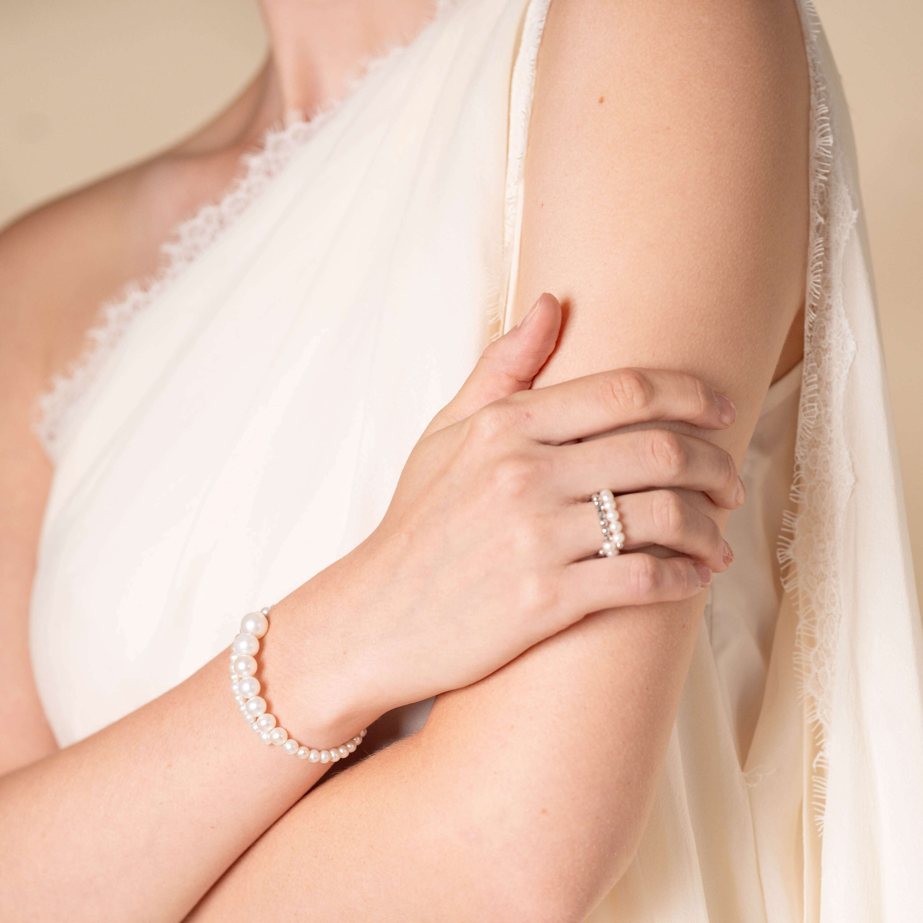 Chic woman donning white dress and Spiral Pearl Bracelet.