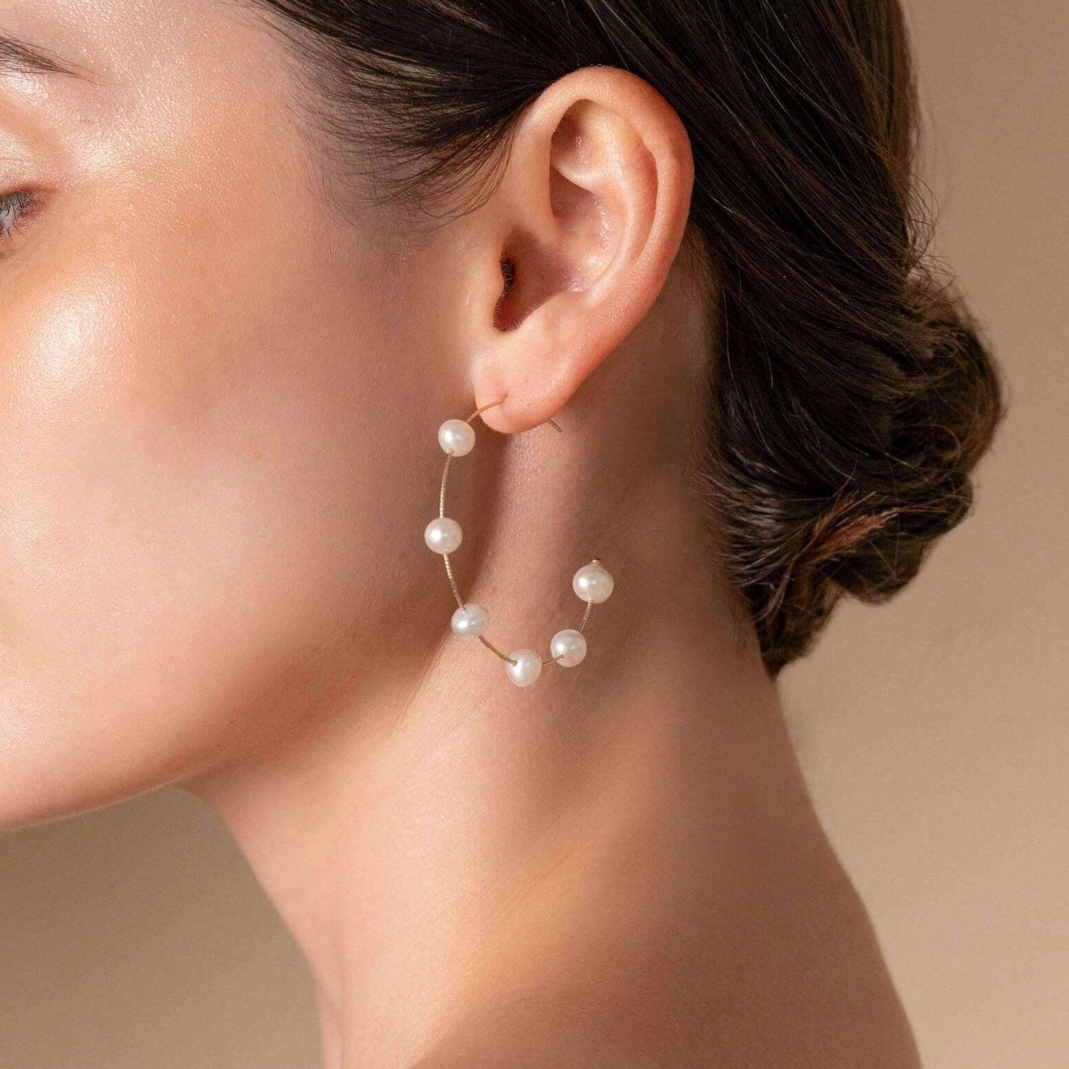 Enhance your look with a white top and Dot Pearl Hoop Piercing earrings like this woman.