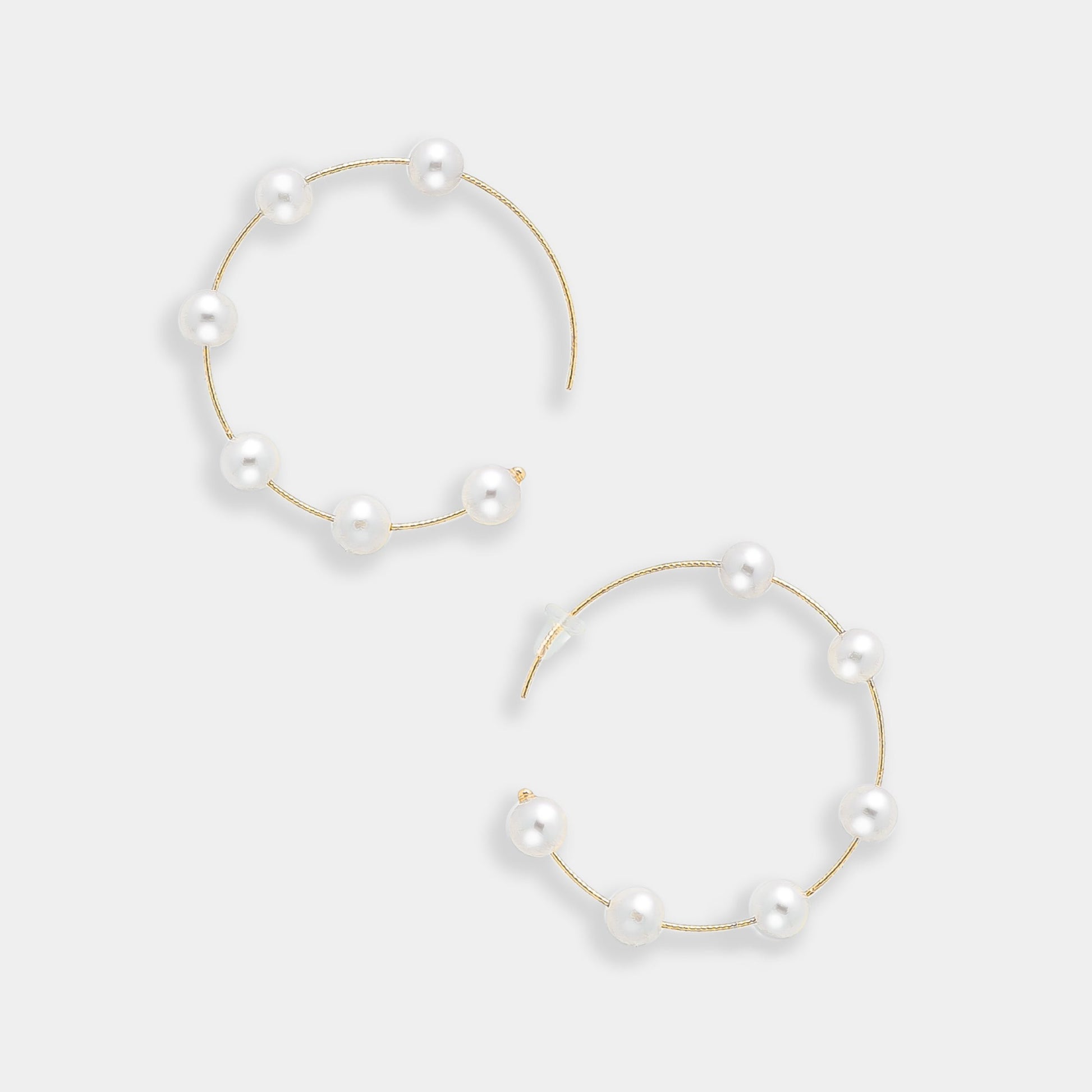 Enhance your look with these stunning gold hoop earrings featuring lustrous white pearls. A timeless accessory for every fashionista.