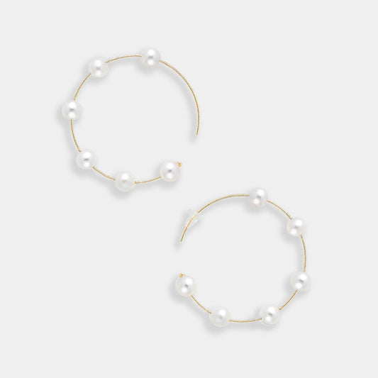 Enhance your look with these stunning gold hoop earrings featuring lustrous white pearls. A timeless accessory for every fashionista.