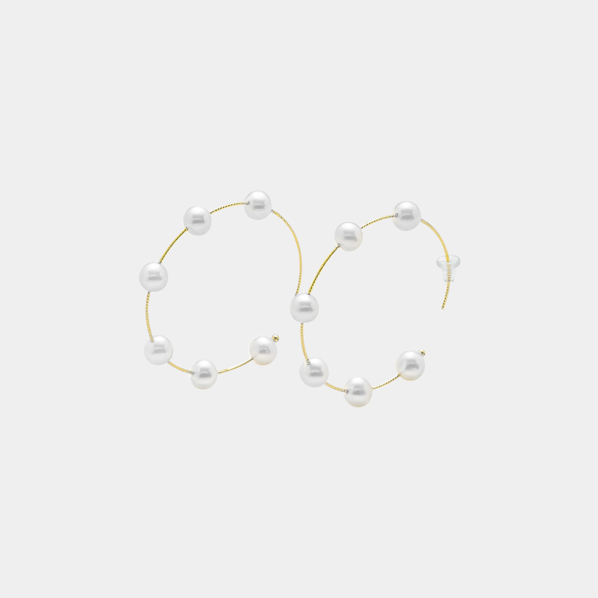 Embrace sophistication with these captivating gold hoop earrings embellished with delicate white pearls. A must-have for any jewelry collection.