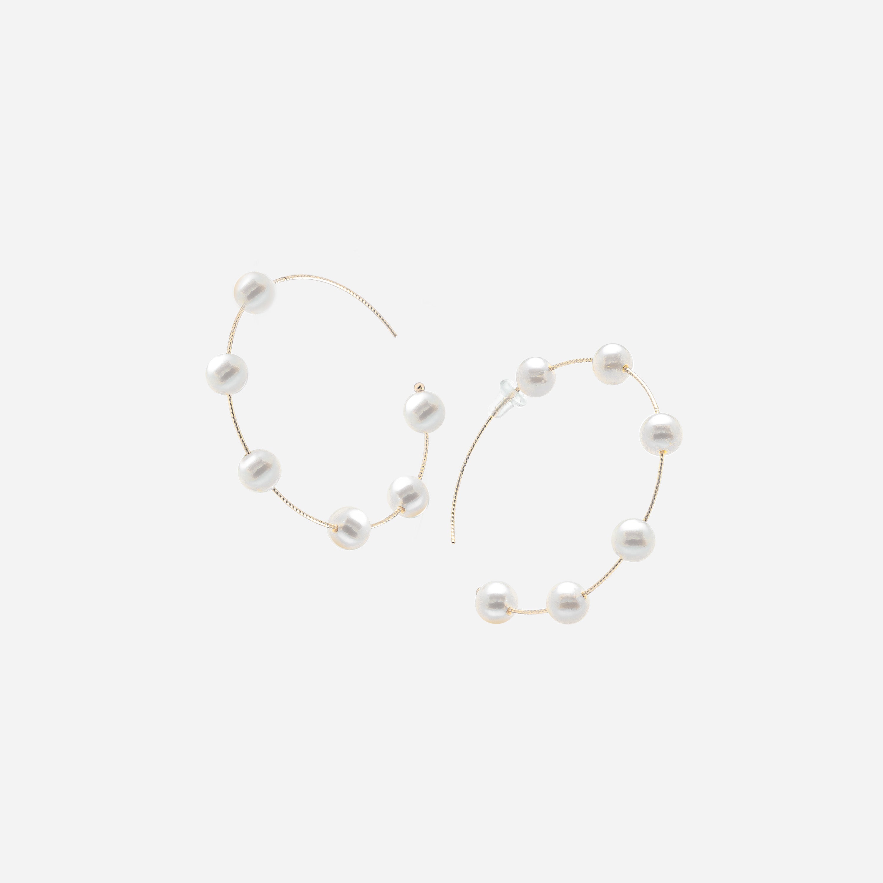 Embrace sophistication with these captivating gold hoop earrings embellished with delicate white pearls. A must-have for any jewelry collection.