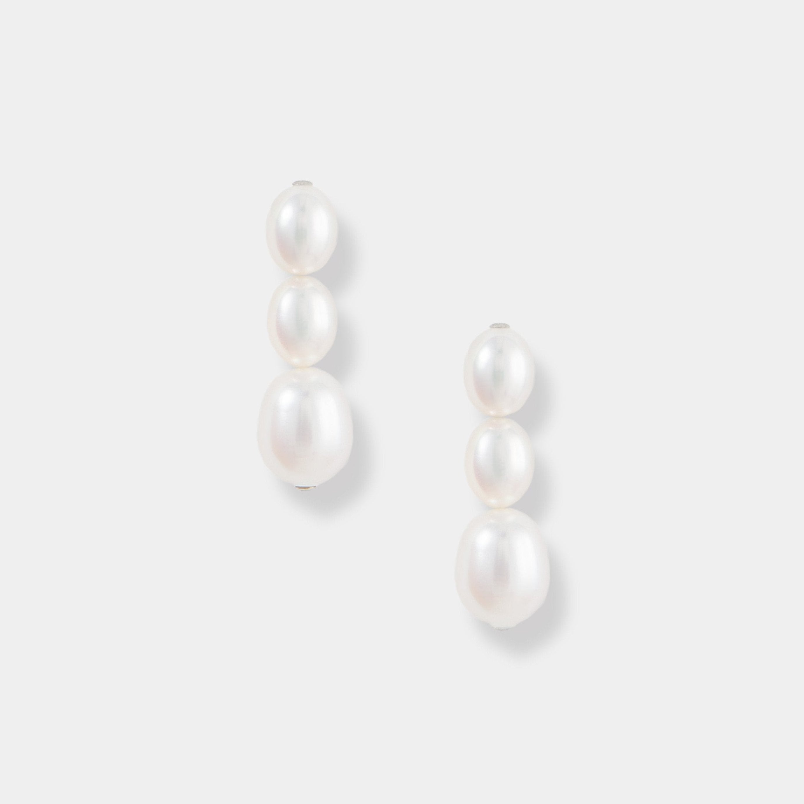 Elevate your style with these stunning oval pearl drop earrings against a clean white backdrop. A timeless accessory.