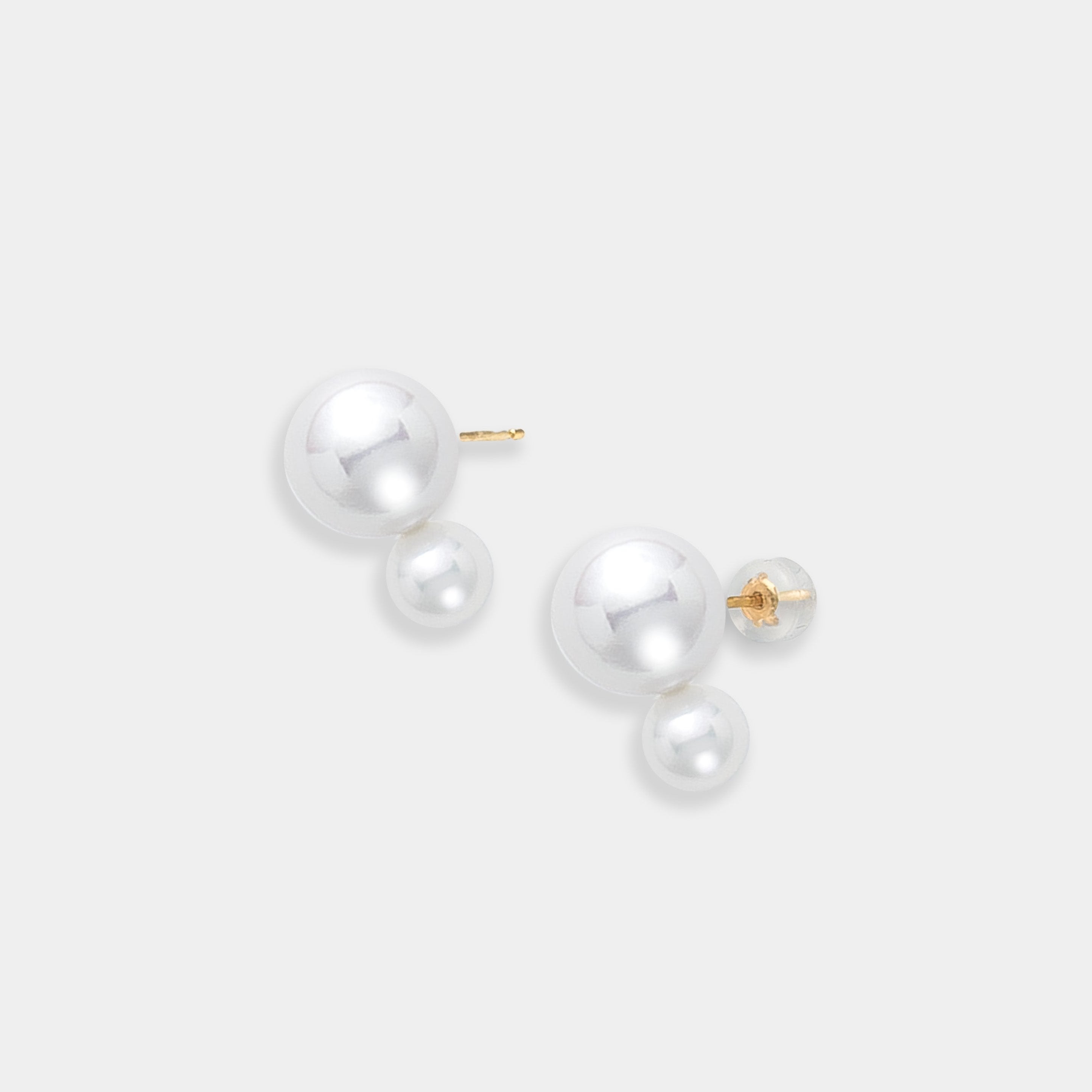 Beautiful freshwater pearl earrings with 18K yellow gold accents, artfully arranged on a smooth white surface.