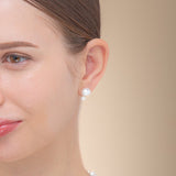 A woman displays a chic freshwater pearl earring in 18K yellow gold, capturing the essence of elegance and luxury.