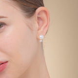 A woman elegantly showcases a freshwater pearl earring set in 18K yellow gold, radiating timeless beauty and sophistication.