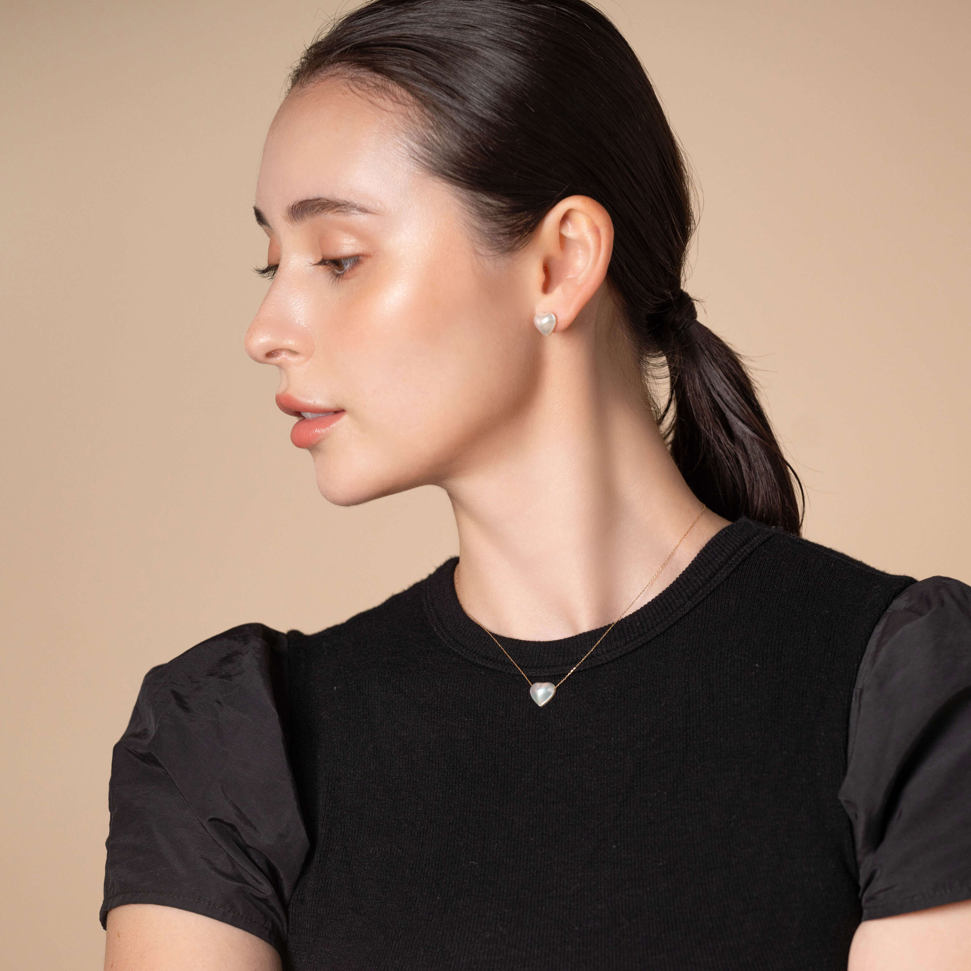 Stylish woman in black shirt wearing Heart Pearl Chain Necklace.