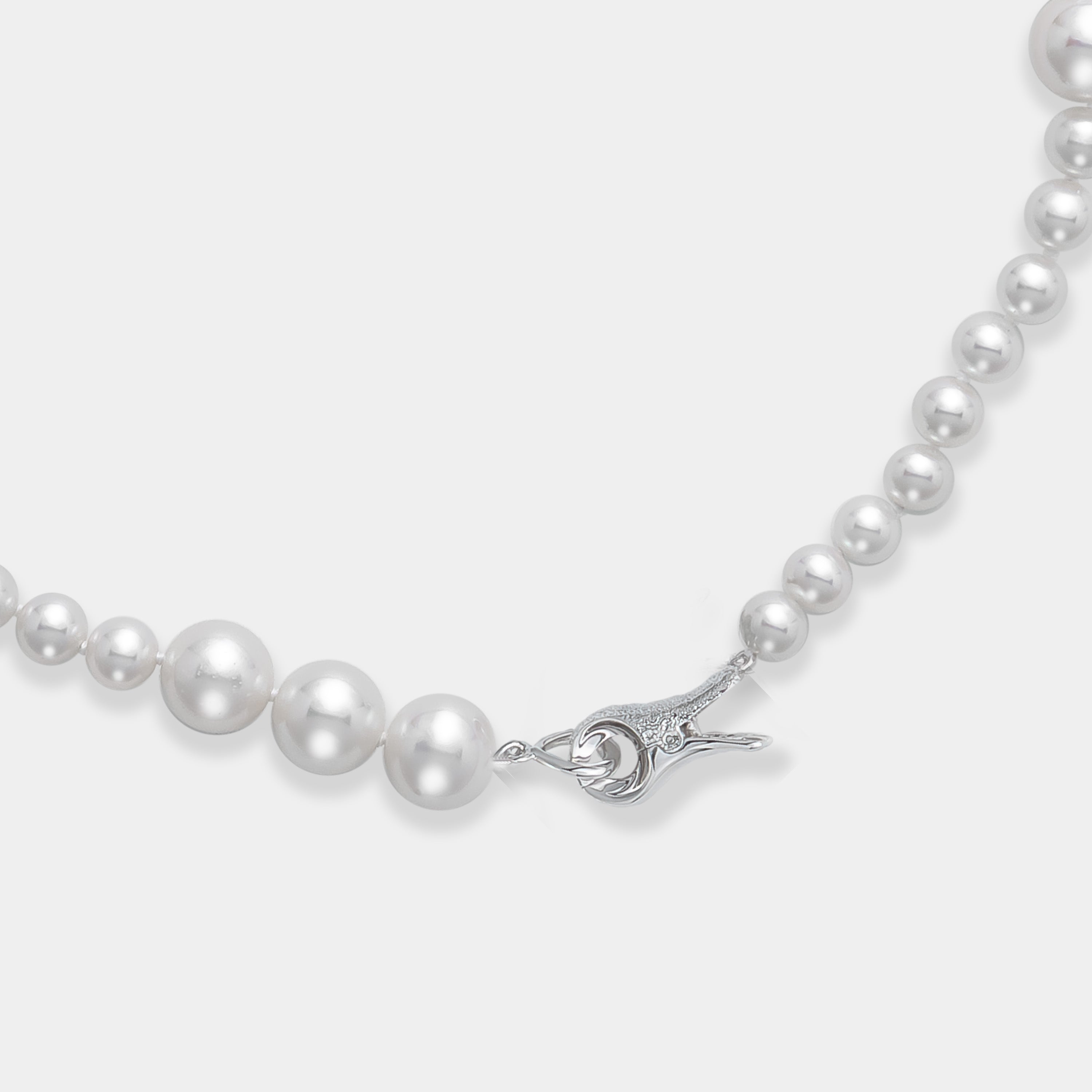 A luxurious long necklace adorned with lustrous freshwater pearls and a sleek silver clasp.