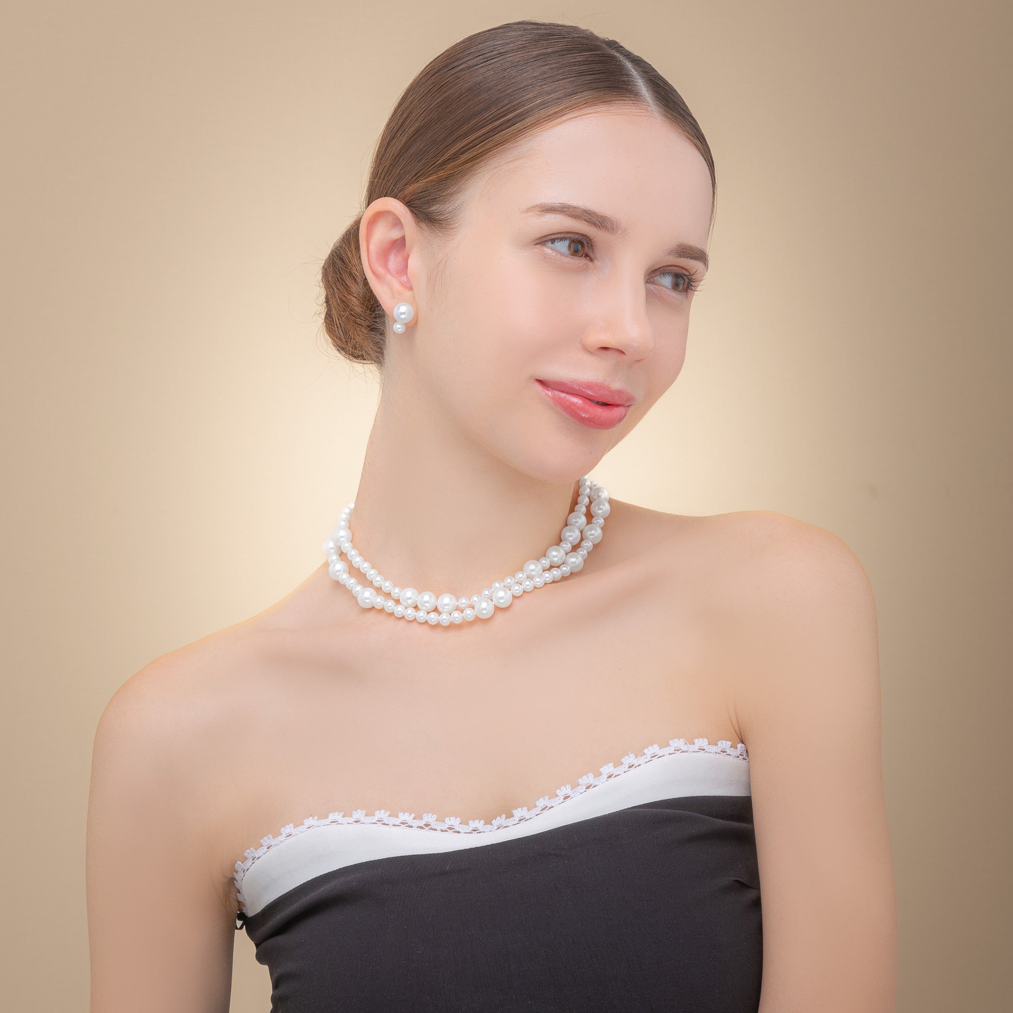 A woman wears a beautiful long freshwater pearl necklace with a silver clasp, embodying elegance and timeless fashion.