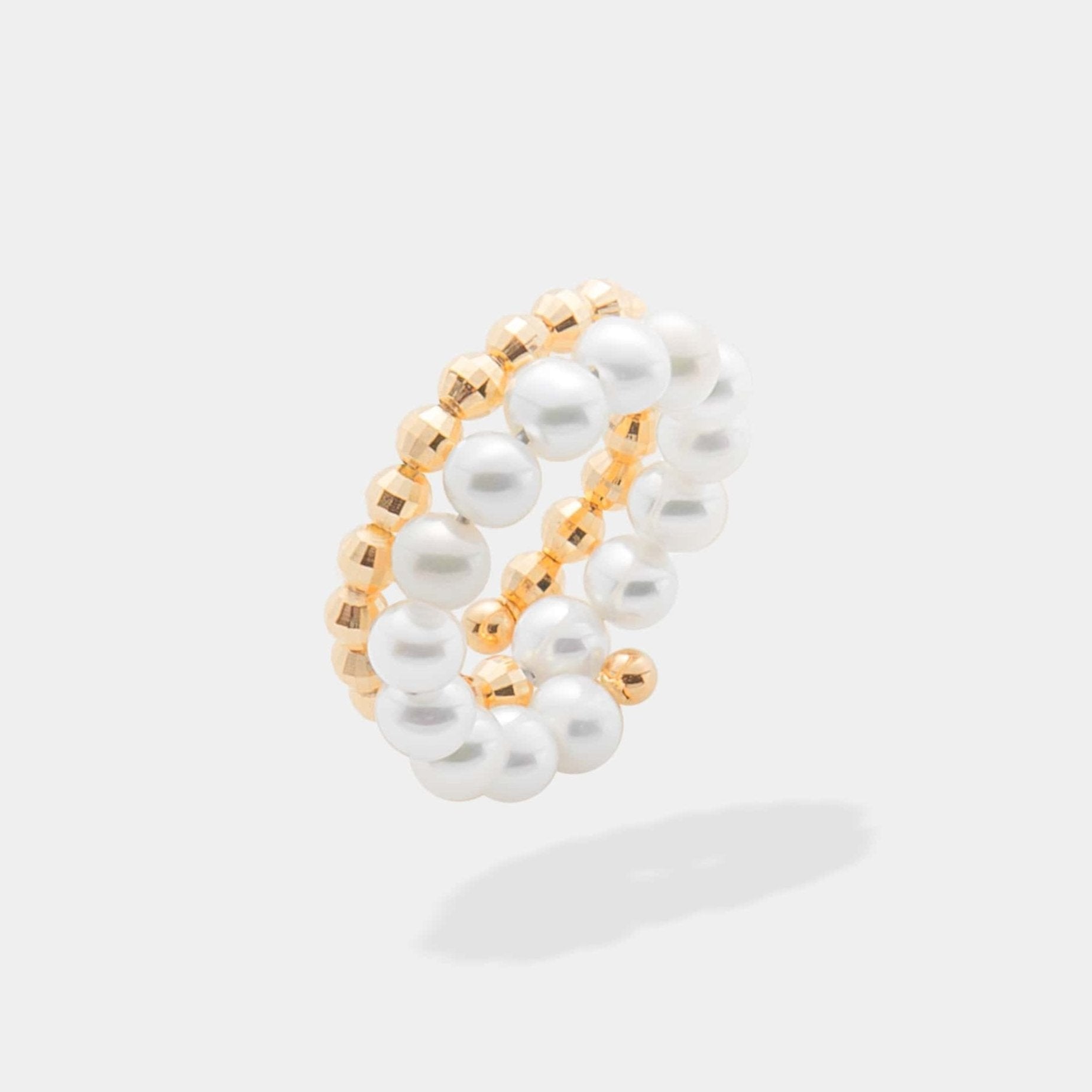 Elegant gold and white pearl ring with a spiral design, perfect for adding a touch of sophistication to any outfit.