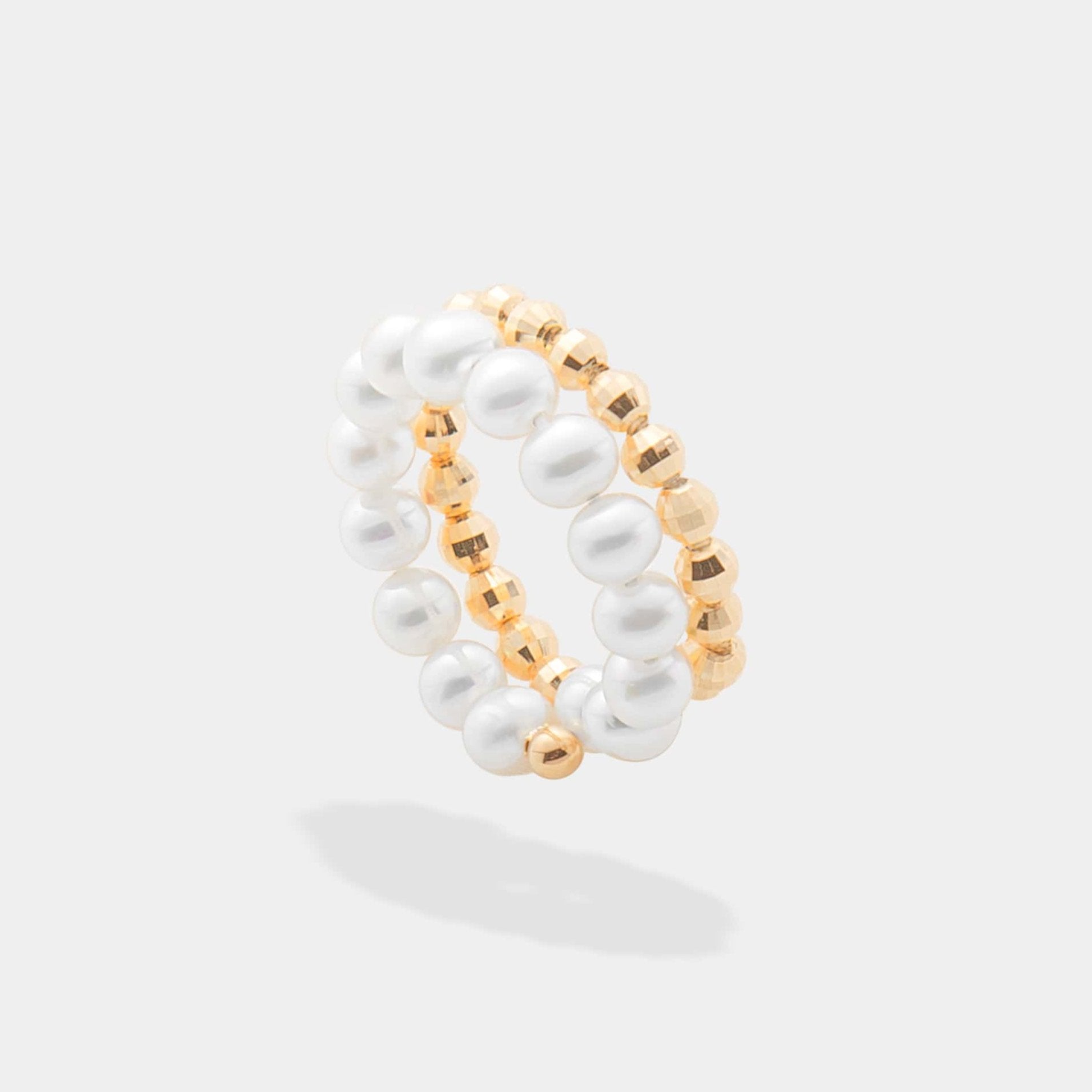 Elegant gold and white pearl ring with a spiral design, perfect for adding a touch of sophistication to any outfit.