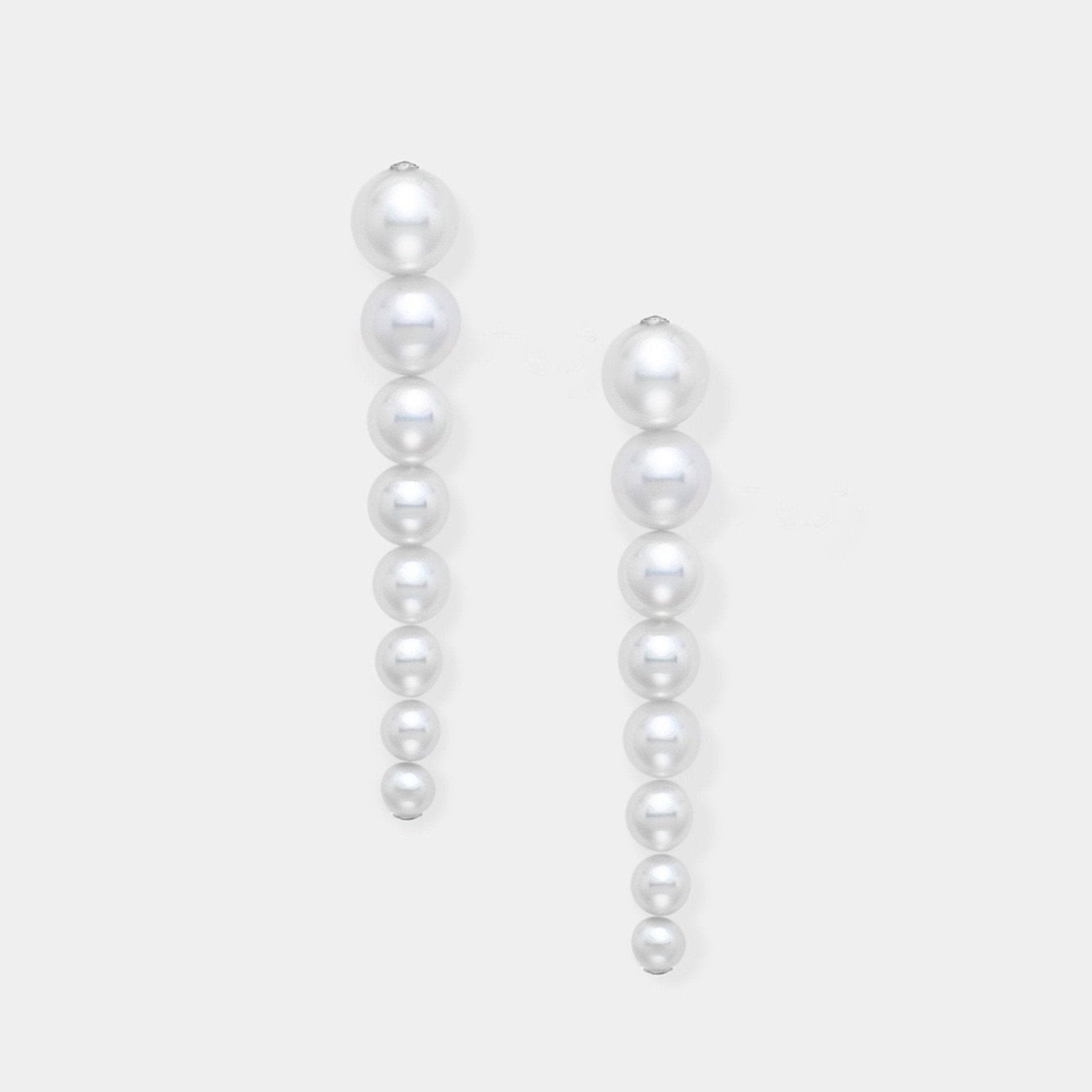 Enhance your elegance with Stella Piercing's exquisite pearl earrings on a pristine white background.