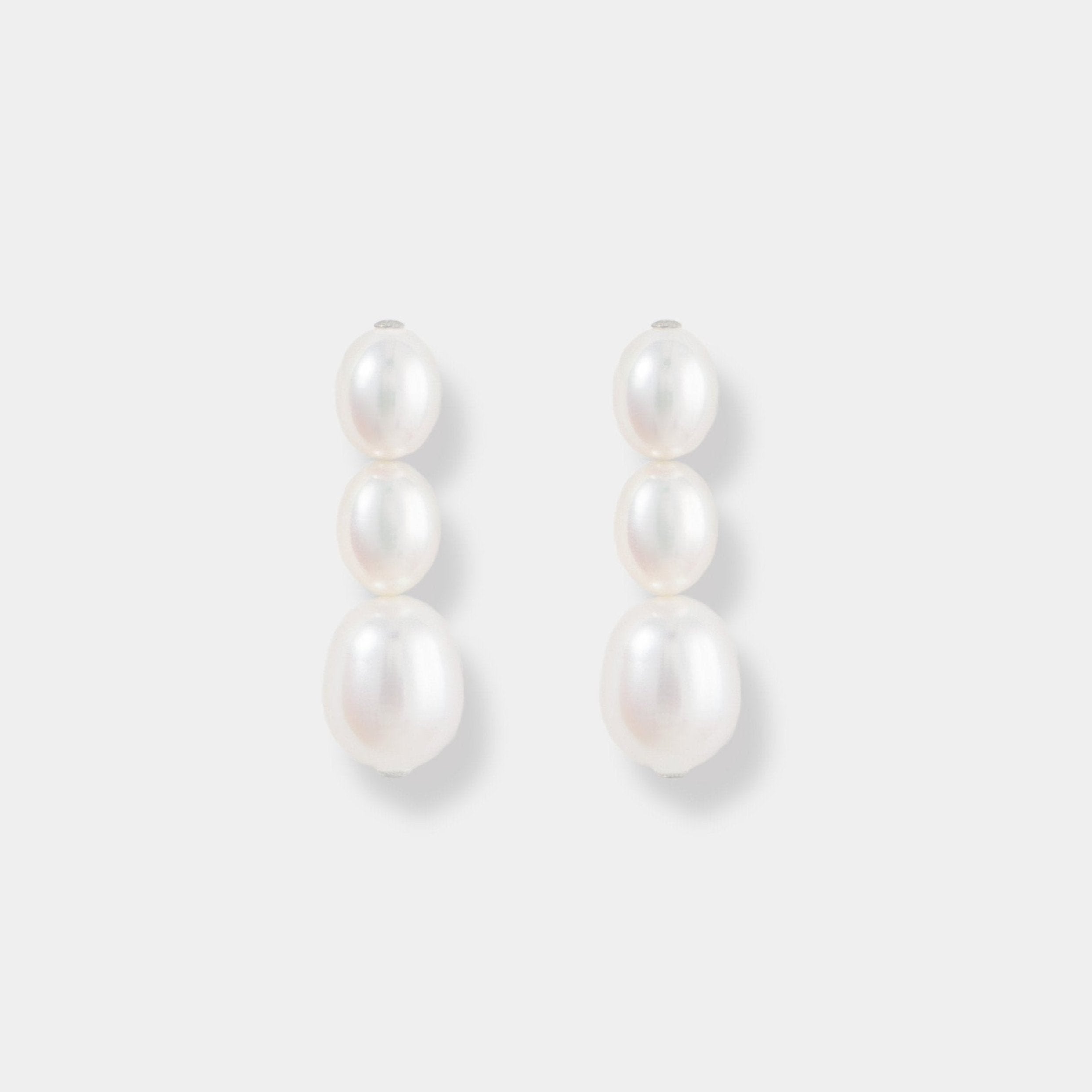 Enhance your elegance with exquisite pearl drop earrings on a pristine white background. Perfect for any occasion.