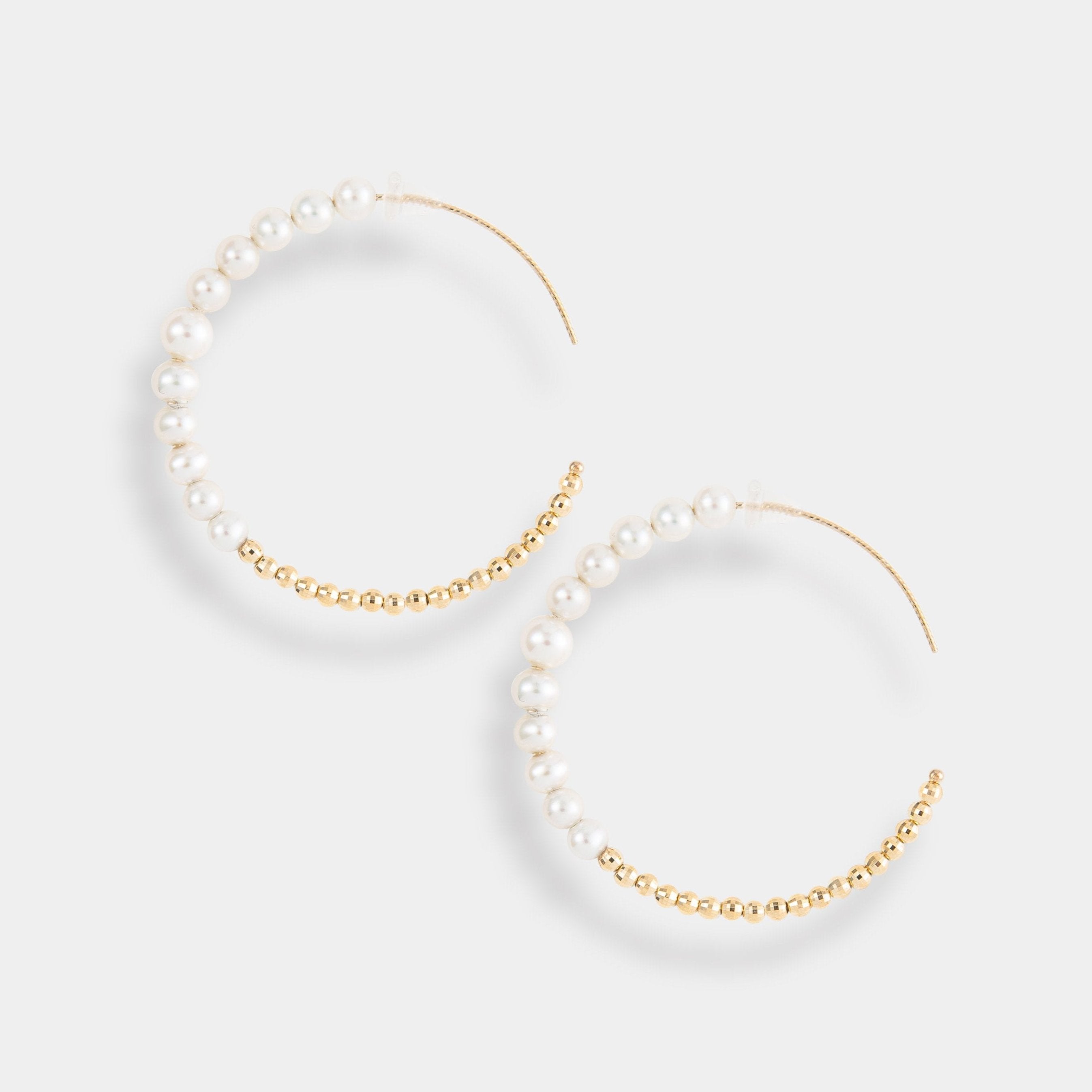 Elegant gold hoop earrings with lustrous pearls, perfect for adding a touch of sophistication to any outfit.