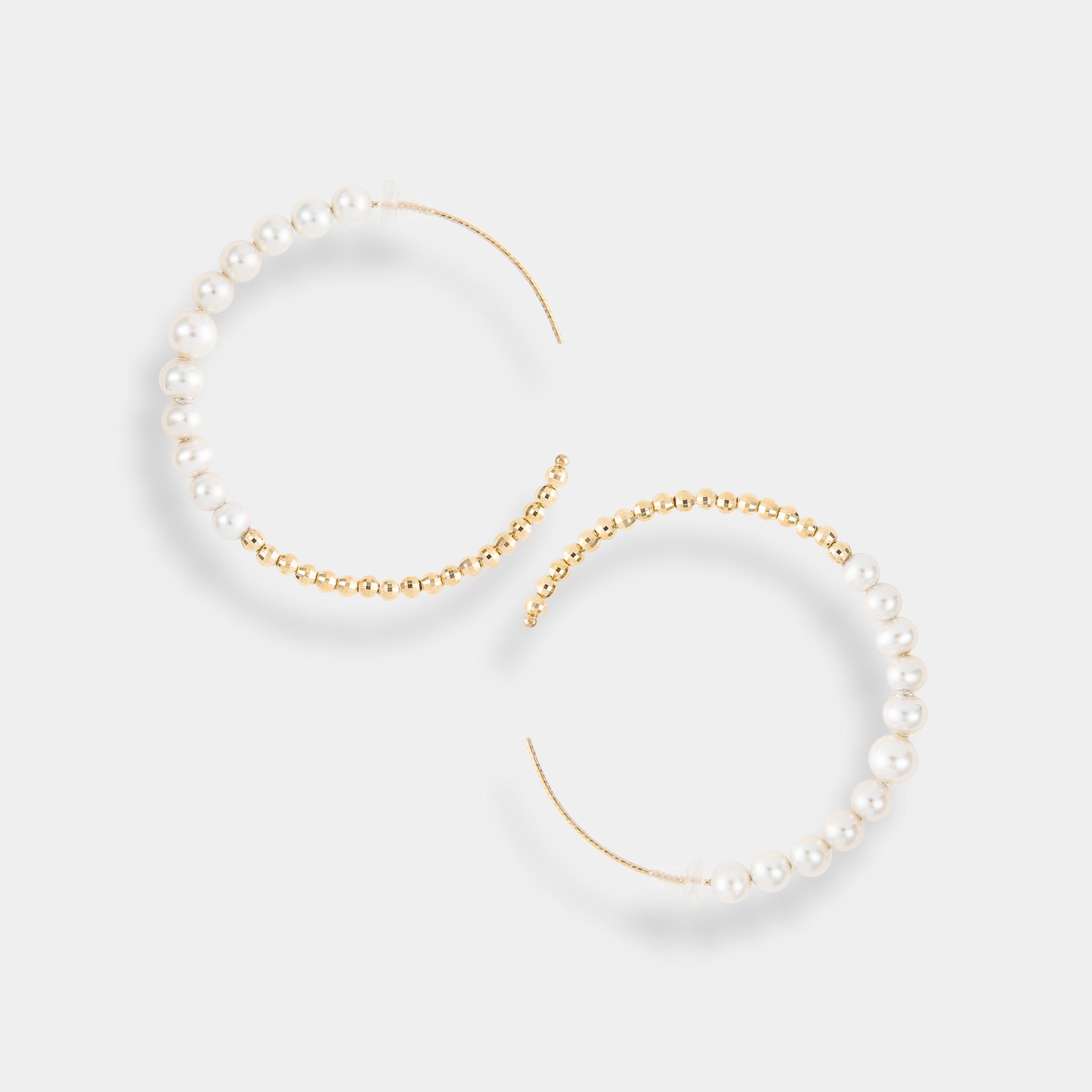 Luxurious gold hoops adorned with beautiful pearls, a must-have accessory for a glamorous look.