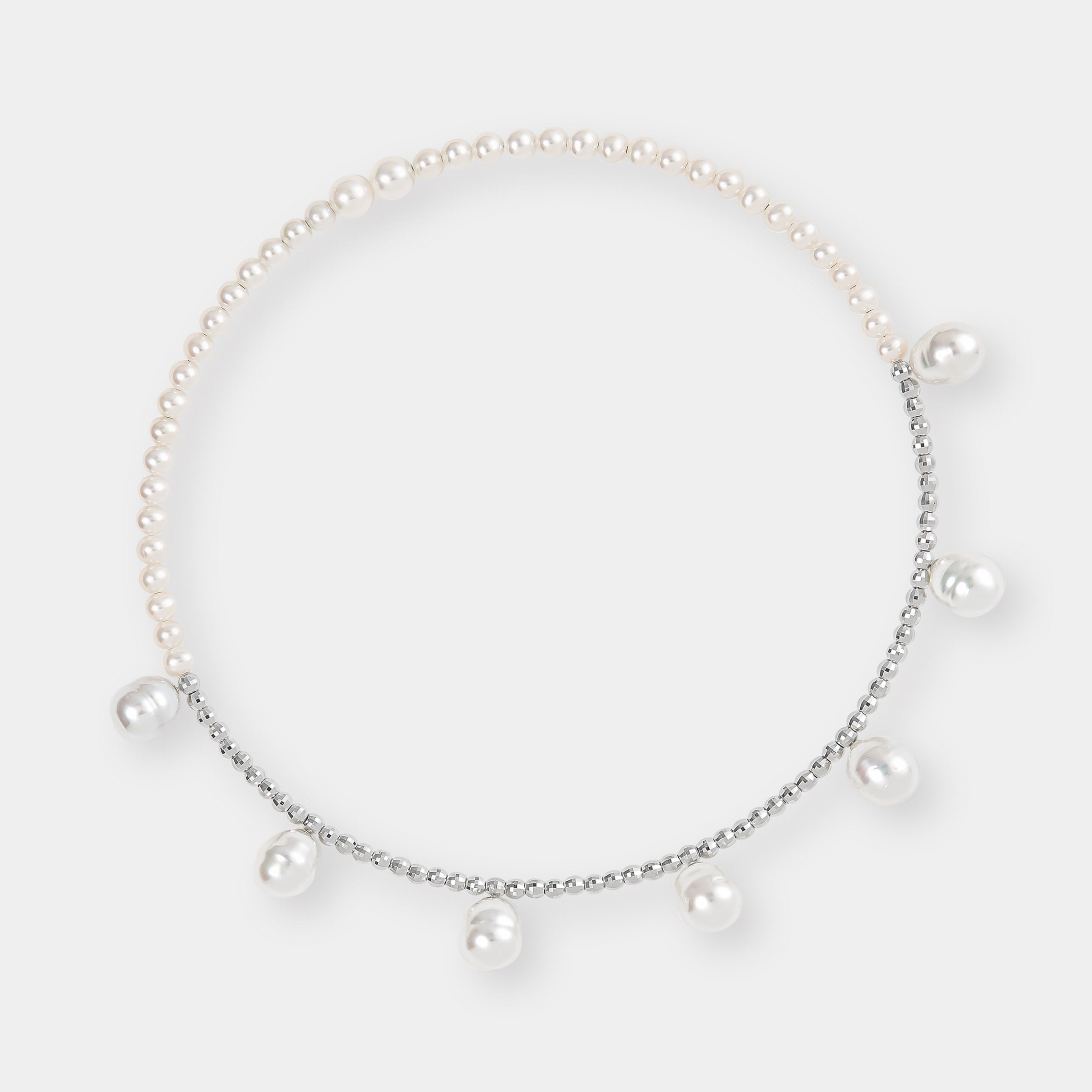 Luxurious pearl and white gold beads against a clean white backdrop, a stunning accessory for any occasion.